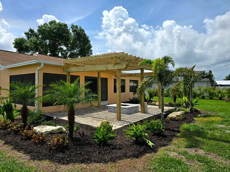 Wood pergola over a paver patio with new plantings